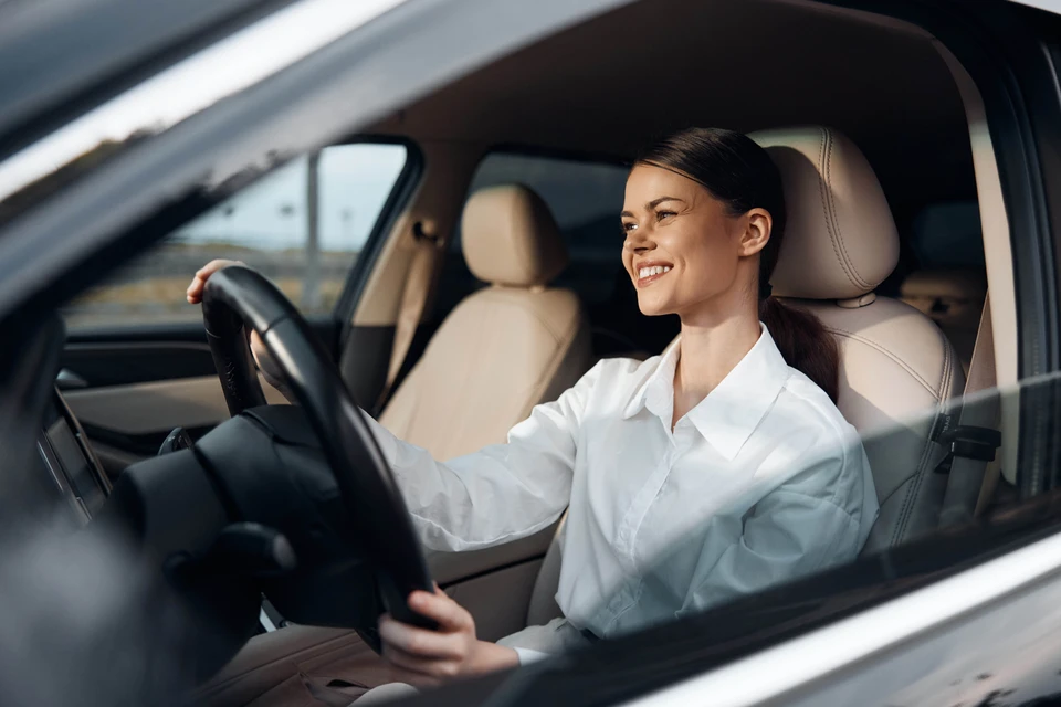 Scène d'intérieur professionnel où deux personnes en costume échangent des clés de voiture au-dessus d'un bureau