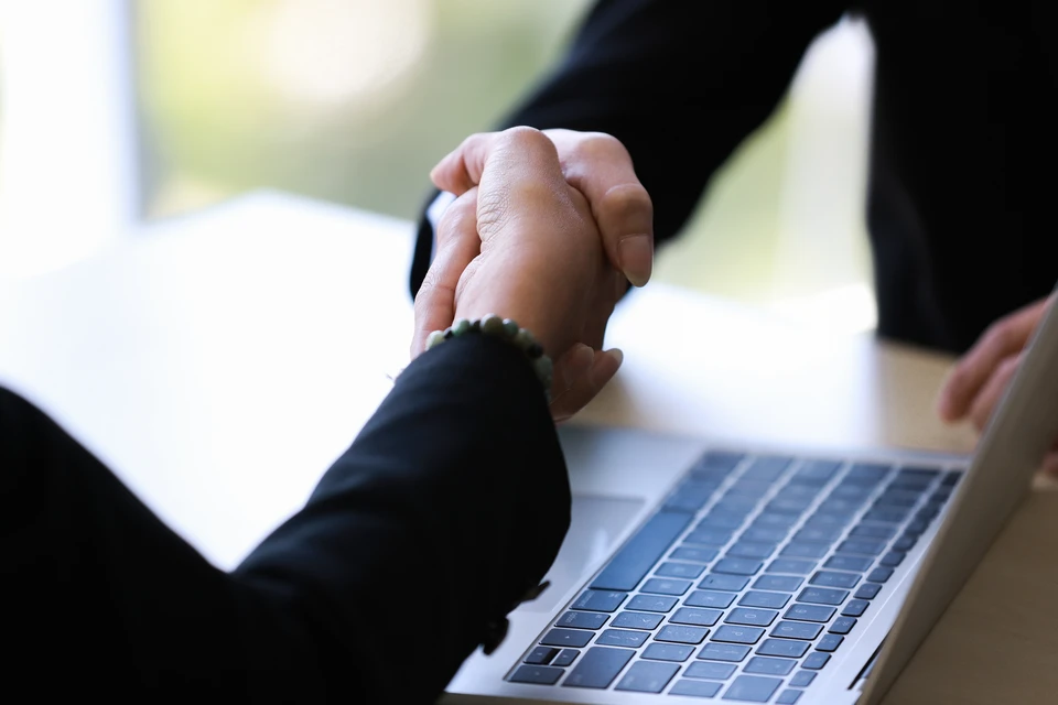 Gestionnaire souriant et prise en main du client, hommes d'affaires satisfaits serrant la main en offrant des contrats financiers, du soutien, de l'aide, une bonne affaire, en concluant un accord, des analyses d'entreprise, des graphiques statistiques sur le bureau