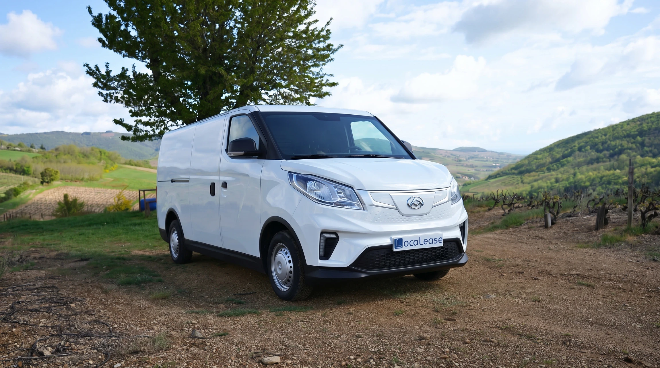 Fourgon utilitaire électrique blanc, stationné sur un chemin de terre en zone rurale viticole